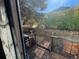 Charming outdoor patio with stone wall, mature trees, and mountain views at 614 Rose St, Georgetown, CO 80444