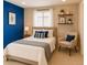Comfortable bedroom with a blue accent wall, complete with decorative shelving and natural light at 3644 Rosewalk Cir, Highlands Ranch, CO 80129