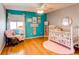 Bright Bedroom with hardwood floors, turquoise accent wall, and white furniture at 3644 Rosewalk Cir, Highlands Ranch, CO 80129