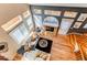 Sun-filled living room with a stone fireplace, hardwood floors, and multiple windows at 3644 Rosewalk Cir, Highlands Ranch, CO 80129