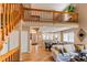Bright living room with hardwood floors, staircase, and open access to the kitchen and dining areas at 3644 Rosewalk Cir, Highlands Ranch, CO 80129