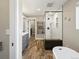 Stylish bathroom boasts gray cabinets, a heated towel rack, a walk-in shower, and wood look tile at 9930 W 82Nd Ave, Arvada, CO 80005