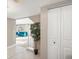 Bright hallway with tiled floors, white closet doors, and a view into the living room with a blue sofa at 9930 W 82Nd Ave, Arvada, CO 80005
