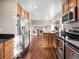 Modern kitchen with stainless steel appliances, granite countertops, wood cabinets, and hardwood floors at 9930 W 82Nd Ave, Arvada, CO 80005