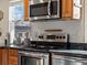 Kitchen showcasing stainless steel oven, wood cabinets, granite countertops, and natural light from the window at 9930 W 82Nd Ave, Arvada, CO 80005