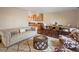 Cozy living room with a neutral sofa, unique chairs, wood floors, and a view into the kitchen and dining area at 9930 W 82Nd Ave, Arvada, CO 80005