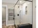 Modern shower with seamless glass, seating area, and matte black hardware fixtures at 9930 W 82Nd Ave, Arvada, CO 80005