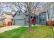 Charming single-Gathering home with gray siding, a red front door, and a well-manicured front lawn at 10405 Dresden St, Firestone, CO 80504