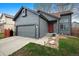 Attractive single-Gathering home features a grey exterior with a red door and a two-car garage at 10405 Dresden St, Firestone, CO 80504