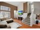 Cozy living room with wood floors, a comfortable sectional sofa, and a view of the staircase at 10405 Dresden St, Firestone, CO 80504
