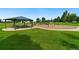 A lovely park includes picnic shelter, swings, and playground equipment on lush green grass at 10405 Dresden St, Firestone, CO 80504