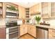Well-lit kitchen features wood cabinets, granite countertops, stainless steel appliances, and stylish decor at 655 S Alton Way # 6A, Denver, CO 80247