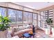 Bright sunroom with large windows offering views of the green backyard, comfortable seating, and plant decorations at 655 S Alton Way # 6A, Denver, CO 80247