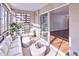 Bright sunroom with views to an indoor living space and a sitting area with white furniture at 655 S Alton Way # 6A, Denver, CO 80247