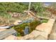 Backyard koi pond with rocky waterfalls surrounded by lush greenery at 7727 W 81St Pl, Arvada, CO 80005