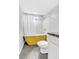 Stylish bathroom with a unique yellow freestanding tub and tiled walls at 7727 W 81St Pl, Arvada, CO 80005