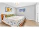 Cozy bedroom with a floral patterned bedspread and hardwood floors, enhanced by natural light at 7727 W 81St Pl, Arvada, CO 80005