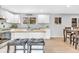 Well-lit kitchen with a center island, white cabinets, granite countertops, and stainless steel appliances at 7727 W 81St Pl, Arvada, CO 80005