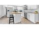 Modern kitchen with white cabinets, stainless steel appliances, butcher block island, and breakfast bar seating at 7727 W 81St Pl, Arvada, CO 80005