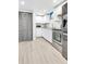 Kitchenette featuring stainless steel appliances, white cabinetry, and wood floors at 7727 W 81St Pl, Arvada, CO 80005