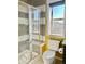 Modern bathroom featuring glass-enclosed shower, gray tiled walls, and a window for natural light at 10150 Belvedere Loop, Lone Tree, CO 80124