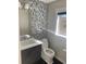 Stylish half bathroom featuring a mosaic accent wall, modern vanity, and a window with natural light at 10150 Belvedere Loop, Lone Tree, CO 80124