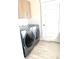 Laundry room with washer and dryer, cabinets, tile floors and a white door at 10150 Belvedere Loop, Lone Tree, CO 80124