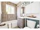 Well-lit bathroom featuring a bathtub, shower, neutral tile, and updated fixtures at 2875 Leyden St, Denver, CO 80207