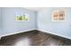 Sunlit bedroom with wood floors, large windows, and a fresh blue color scheme at 2875 Leyden St, Denver, CO 80207