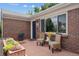 Inviting front porch with wicker chairs, a small table, and colorful potted plants near the front door at 2875 Leyden St, Denver, CO 80207