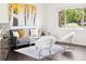 Bright living room features a gray sofa, stylish decor and natural light streaming through the window at 2875 Leyden St, Denver, CO 80207