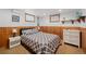 Bedroom with patterned bedding, bedside tables, and light wood paneling at 11011 Kendall Way, Westminster, CO 80020