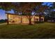 Backyard at dusk with covered patio, outdoor seating, and a lush green lawn at 11345 W 38Th Ave, Wheat Ridge, CO 80033