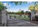 Ornate gated entrance featuring brick pillars, decorative metalwork, and a private drive at 11345 W 38Th Ave, Wheat Ridge, CO 80033