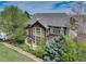 View of the home's backyard with a patio, mature trees, and landscaping at 12451 Turquoise Terrace Pl, Castle Pines, CO 80108