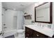 Bathroom featuring a shower over the tub, wood accents, and a white tiled wall at 12451 Turquoise Terrace Pl, Castle Pines, CO 80108