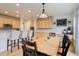 Bright dining area featuring hardwood floors, a wooden table with black chairs, and a kitchen bar with upholstered stools at 12451 Turquoise Terrace Pl, Castle Pines, CO 80108