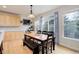 Bright dining area with wood floors, large windows, and a rustic table set at 12451 Turquoise Terrace Pl, Castle Pines, CO 80108