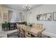 Bright dining room with a wood table, stylish rug, modern chandelier, and ample natural light at 12451 Turquoise Terrace Pl, Castle Pines, CO 80108