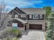 Charming two-story home with brick and brown siding, complemented by a spacious driveway at 12451 Turquoise Terrace Pl, Castle Pines, CO 80108
