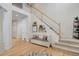 Inviting foyer featuring light wood floors, a staircase with white railings, and a cozy bench with decorative pillows at 12451 Turquoise Terrace Pl, Castle Pines, CO 80108