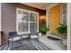 Inviting front porch featuring dark brown siding, a patterned rug, and comfortable chairs at 12451 Turquoise Terrace Pl, Castle Pines, CO 80108