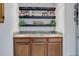 Wet bar featuring sink, tiled countertop, wooden cabinets, and bar shelving at 12451 Turquoise Terrace Pl, Castle Pines, CO 80108