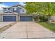 Charming two-story townhouse featuring a blue facade, stone accents, and a spacious driveway for convenient parking at 6110 Raleigh Cir, Castle Rock, CO 80104