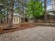 Landscaped backyard featuring a stone patio, shed, and trees providing a private outdoor space at 12599 Elm St, Thornton, CO 80241