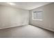 This bedroom features neutral paint and carpet with a large window at 12599 Elm St, Thornton, CO 80241
