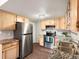 This bright kitchen is complete with stainless steel appliances, wooden cabinets and updated counter tops at 12599 Elm St, Thornton, CO 80241