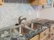 The kitchen sink has granite counters and stainless faucet at 12599 Elm St, Thornton, CO 80241