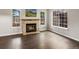 Bright living room with a stone fireplace, hardwood floors, and large windows offering plenty of natural light at 12599 Elm St, Thornton, CO 80241