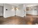 Open-concept living room with hardwood floors, a staircase, and a modern lighting fixture creating a cozy atmosphere at 12599 Elm St, Thornton, CO 80241